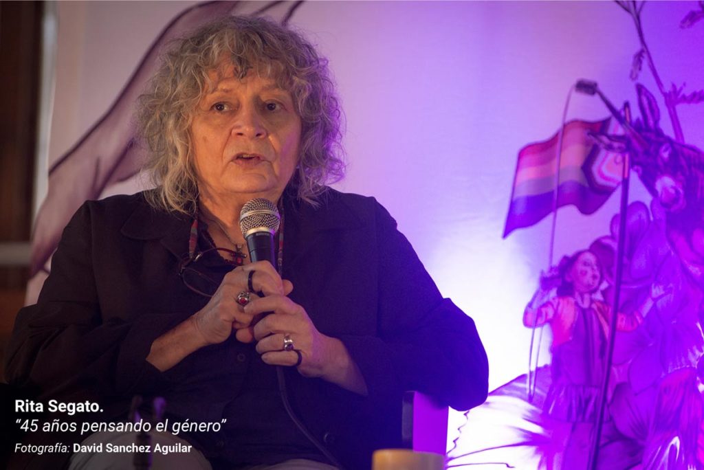 Rita Segato, durante su ponencia en la III Escuela Feminista AMA Asturies, con la gráfica de fondo de Eva Cortés Ilustra