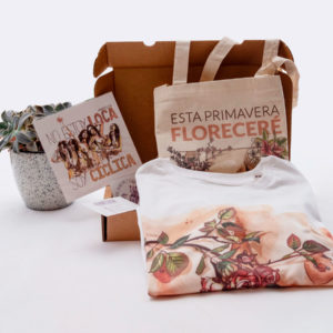 En la imagen se ve un ejemplo del pack de productos de temática feminista "Cuerpos Diversos". En la fotografía se puede observar una lamina pequeña DIN A5 (el pack incluye dos) que se titula "No estoy loca, soy cíclica" , también se ve una camiseta con uno de los conocidos diseños de pechos de Eva Cortés, y una bolsa de tela (tote bag)con la ilustración "Esta primavera floreceré, fuera del canon de tu mollera"